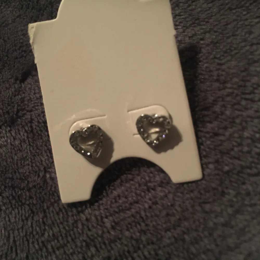 Ett par söta helt oanvända silvriga örhängen i form av hjärtan med tillhörande halsband (pris kan absolut diskuteras). Accessoarer.