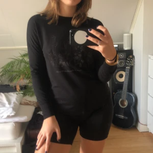 Långärmad tröja - Svart långärmad tröja med blomprint från HM. Strl. S.