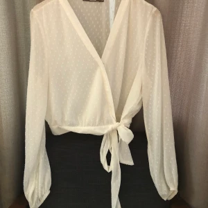 Omlottblus stl M - Blus från bik bok i semi-sheer material. Mönstrat tyg. Knytes i midjan. Endast använd vid ett tillfälle då det var fel storlek för mig. Alltså, är den i princip i nyskick