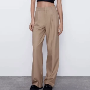 Beiga kostymbyxor - Jättesnygga beiga kostymbyxor från Zara i storlek S men passar S-M. Köpt av en tjej här på Plick men säljer vidare då de inte riktigt passade mig. Bilderna är från förra säljaren, som är 172cm lång 🤍💫