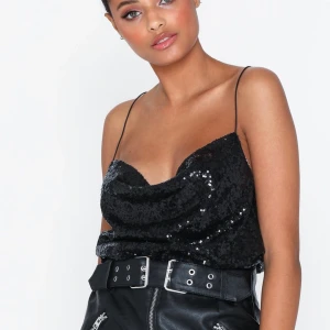 Svart paljett-linne med öppen rygg - Svart paljett-linne från Nelly med öppen rygg, storlek 36 (helt slutsålt på deras hemsida). Perfekt för nyår, passar tyvärr inte mig i storleken så helt oanvänd med prislapp kvar. Köparen står för eventuell fraktkostnad💕