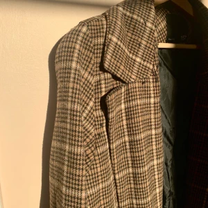 Rutig kappa  - Rutig lång kappa. I storlek L men jag har själv S och kan ha den, tror man kan ha den om man har storlek L också, men då kommer den sitta lite mer figurnära. 