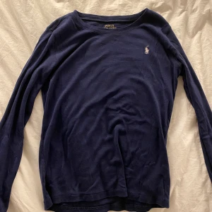 Polo Ralph Lauren tröja - Mörkblå ralph lauren tröja med ljusrosa märke. I bra skick knappt använd. Storlek XL men passar XS, S och M.