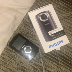 Kamera - Filmar och fotar, minneskort på 2GB medföljer. Jätte enkel att föra över till dator via USB som sitter i kameran som man bara viker ut enkelt!  Namn: PHILIPS Pocket camcorder ESee 1080p    Bilderna blir som engångskamerabilder. Jag har bilder jag kan skicka om man vill se hur resultatet blir
