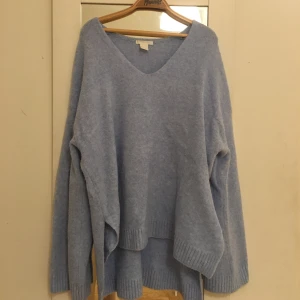 Stickad tröja - Jättefin stickad tröja i ljusblå. Väldigt vid i passformen med djup ringning och vida ärmar. 