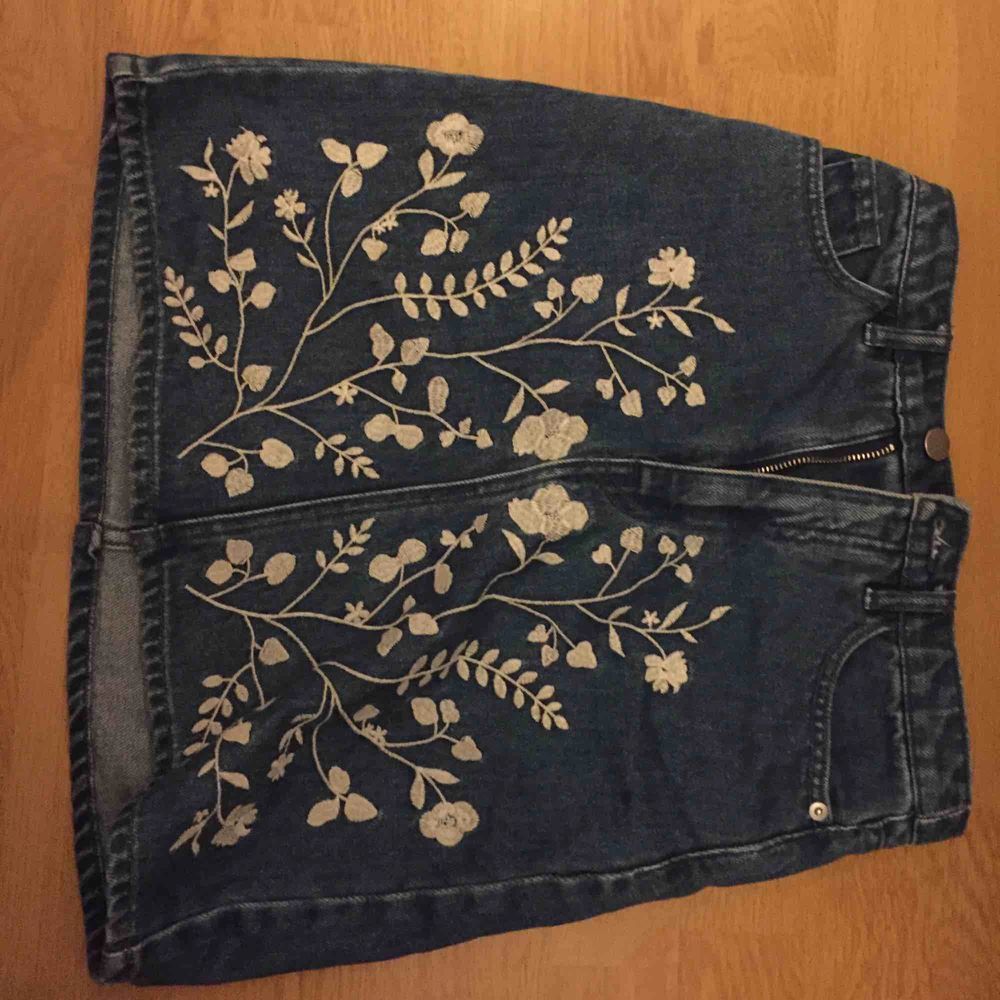 Somrig jeanskjol med broderade blommor på!  Använd ungefär 5 gånger max. . Kjolar.