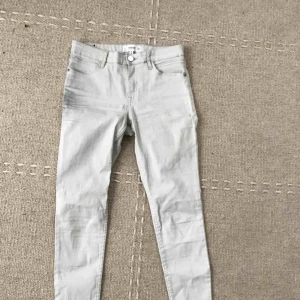  - Oanvända vaxade ljusgrå byxor från Mango