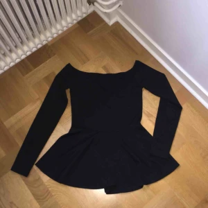  - Svart axellös volang/peplum topp från Nelly. Köparen står för frakten