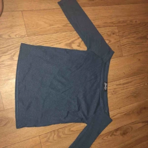  - En fin marinblå off shoulder tröja som är ungefär vid armvecken längd på armarna 