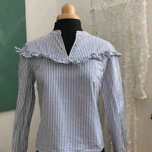  - Blå-vitrandig blus ifrån MQ. Storlek 34. 60 kr inklusive frakt.