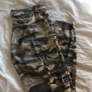  - Gråa camobyxor från Madlady   Tyget är av tjockare kvalité och har stretch. Fickor ovanför knäna och vid sidorna.  Storlek: M (tillverkningsfel så det är M trots att taggen säger L) Kan fraktas för 59 kr extra eller mötas upp i Lund/Malmö