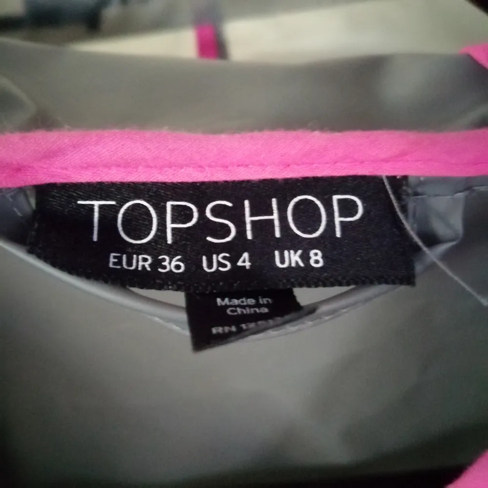 Köpt i UK från Topshop. Semi-transparent grå regnjacka med rosa detaljer och svarta knappar. Regular fit. . Jackor.