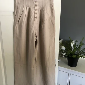 Culottebyxa  - Beige culottebyxa från Ellos med hög midja i linneliknande material. Endast testad! Storlek S. Nyskick! Nypris 399kr. Porto 63kr 
