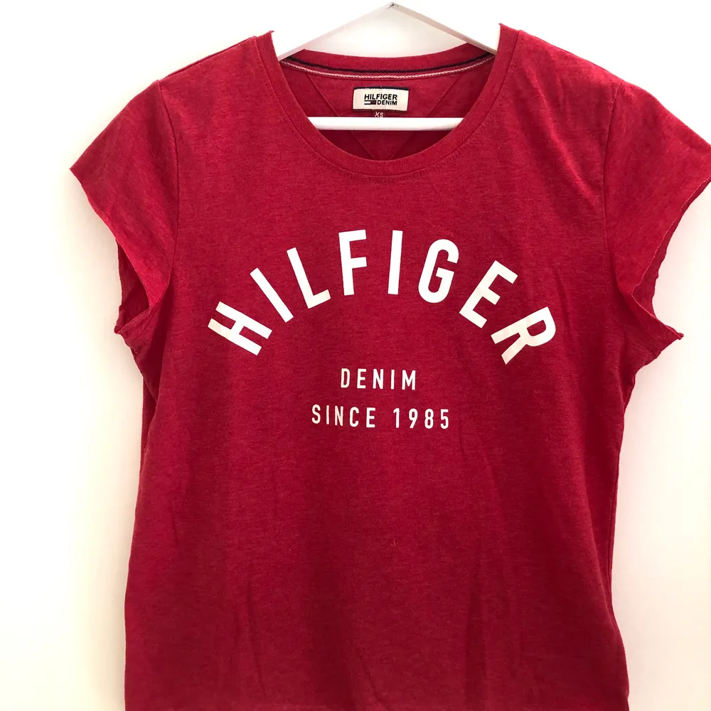 Röd Tommy Hilfiger T-shirt i storlek XS. Mycket gott skick. Något croppad modell med avklippta sömmar nedtill och vid ärmar. . T-shirts.