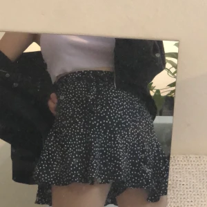 Kjol  - Svart prickig kjol med dragkedja och ett band för att spänna midjan. Det har också undershorts. Köparen står för frakten