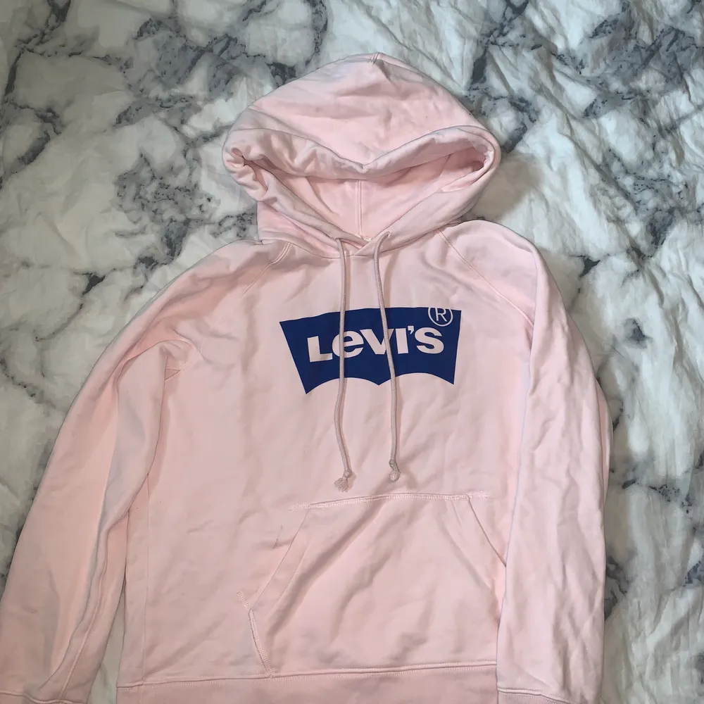 En rosa Levis hoodie med blå logga, storlek S men passar M också. Aldrig använd. Hoodies.