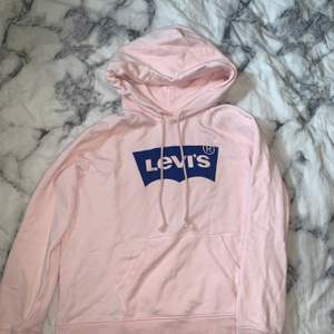 En rosa Levis hoodie med blå logga, storlek S men passar M också. Aldrig använd