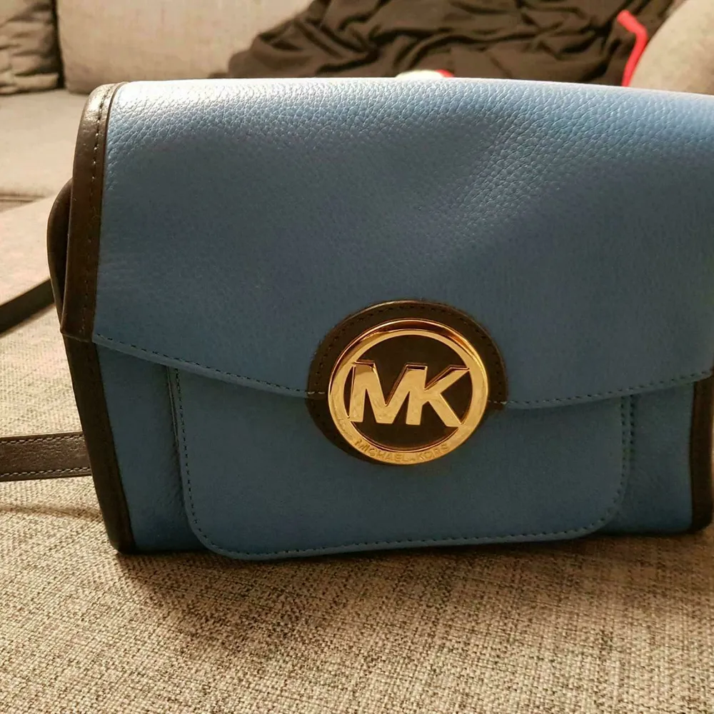 Jag säljer min blå Michael Kors handväska. Jag bär aldrig påsen, varför jag vill sälja den nu.   Mått:   Bredd: 25 cm  Höjd: 21 cm  Djup: 11 cm. Väskor.