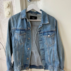 Jeansjacka strl XS - Blå jeansjacka i storlek XS, men ganska stor för att vara en XS. Från BikBok. Köparen står för frakt!