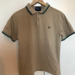 fred perry piké - slim fit - beige fred perry-piké med gröna och bruna detaljer i fint använt skick. storlek medium slim fit. hämtas i malmö eller skickas med posten (köpare står för frakten). se även mina andra annonser för ev samfrakt.