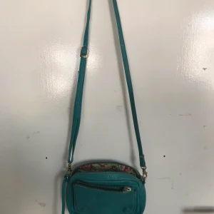 Liten axelväska  - En turkos axelväska med många fack och fin insida. Har används några gånger men är i bra skick. Köparen står för frakt 