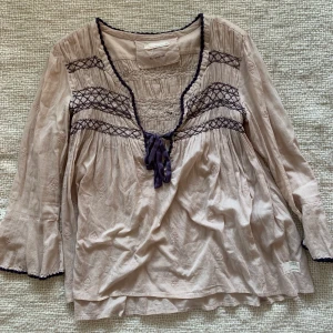 Odd Molly blus - Beige oddmolly blus med lila broderi och snörning. Använd ett par gånger, väldigt bra skick! Oddmolly storlek 2, skulle säga att de är storlek S/M.