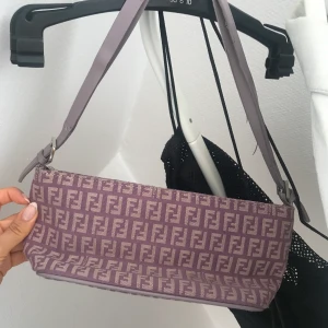 Väska - Baguette väska köpt second hand. Aldrig använd av mig. Har sprickor i bandet som syns på bild 3 