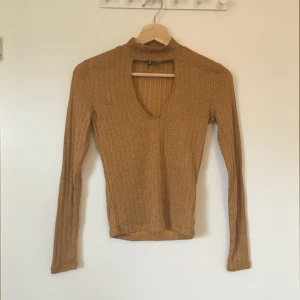 Guldglittrig tröja med krage från H&M - Guldglittrig tröja med krage från H&M divided. Stl XS. Gott skick, knappt använd. Frakt betalas av köparen.