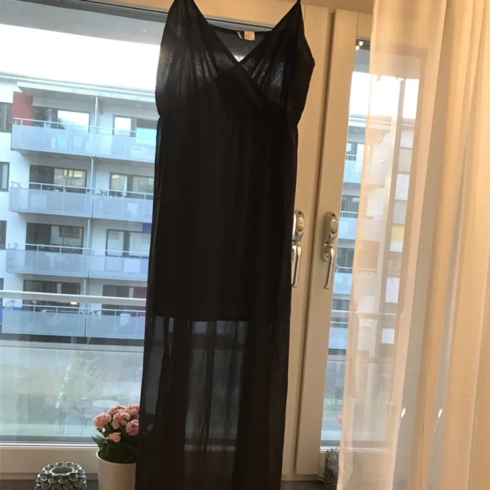 Super snygg svart klänning. Svart transparent tyg ytterst och en kortare inner klänning under så att man inte ser igenom. Väldigt fin och elegant! Sparsamt använd, 1-2 gånger. Lös i passformen. Köparen står för eventuell frakt. . Klänningar.