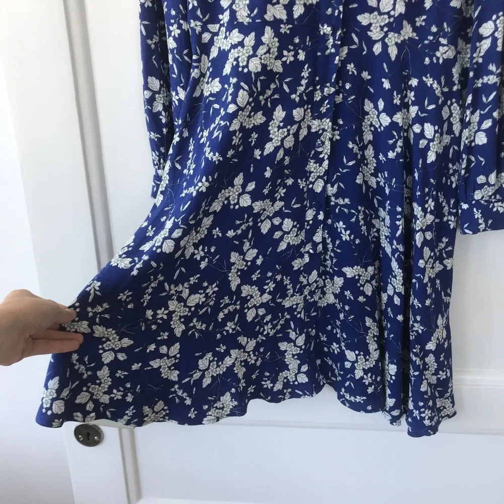 Underbar klänning från H&M. Lätt utsvängd kjol. Sval och skön. Beklädda knappar längs hela framsidan.  Frakt 40kr. Klänningar.