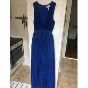  - Oanvänd klänning med 4 lager kjol som ger fin midja. Djup v-ringning. Jag har inte användning för den men sparat den för att den är såå fin! Hoppas någon annan kan utnyttja den :)   Strl 36. Köparen betalar frakt. Finns vid Fridhemsplan i Sthlm! 