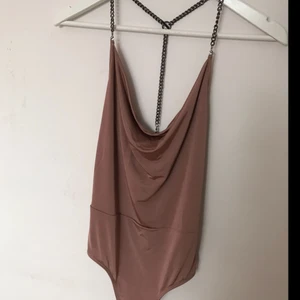  - nude/ gammelrosa body från Miss Selfridge. aldrig använd, har lapparna kvar. kedjorna/ axelbanden går att ta av. köpt för ca 300:- kom med bud, paketpriser vid köp av flera plagg. köparen betalar frakt.