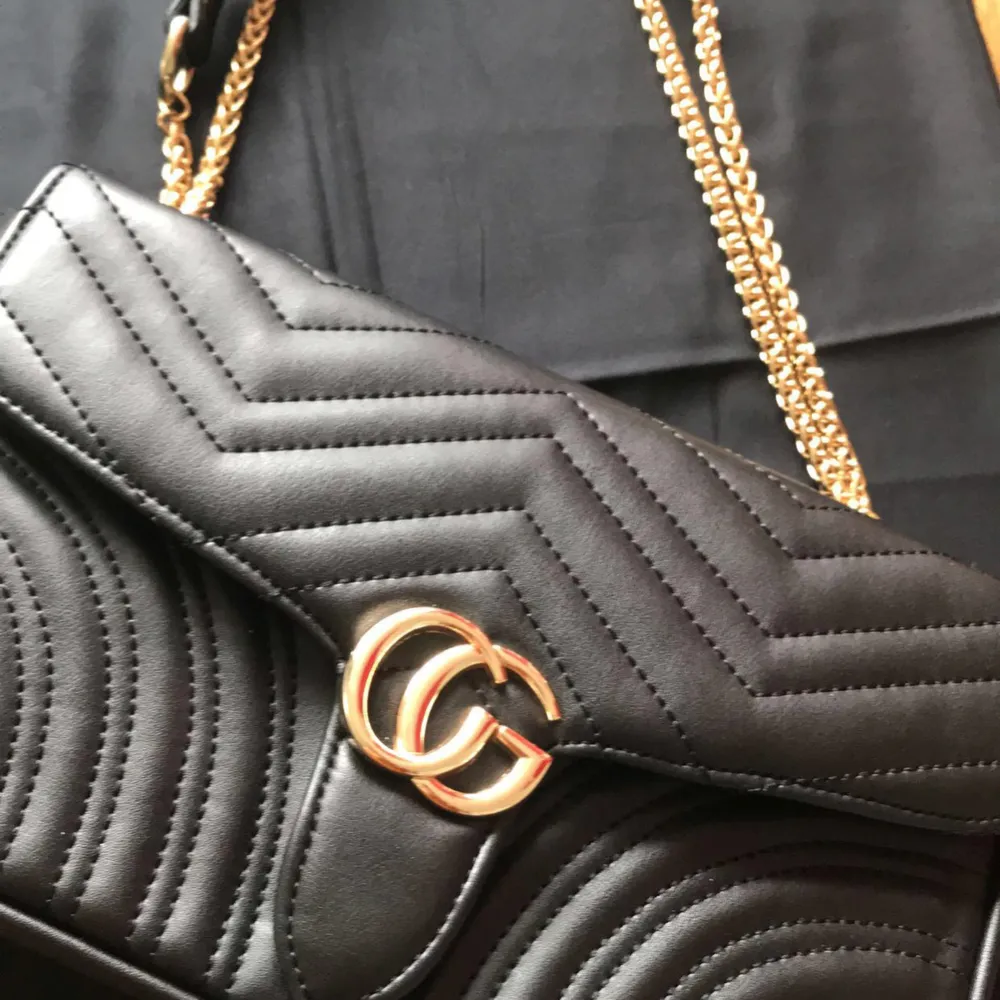 Kopia Gucci svart väska med guld färgad drag kedja . Medium modellen nyskick använd lite .. Väskor.