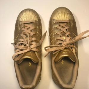  - Helguldiga Addidas Superstars. Använda kanske 4-5 gånger, inte ingådda. Supensnygga och bekväma men jag använder dem aldrig!