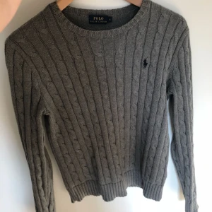  - Hej jag säljer denna gråa kabelstickade tröjan från Ralph Lauren. Den är använd 2-3 gånger och anledningen till att jag säljer den är för att jag inte använder den längre. Superfräsch nu till sommaren med ett par vita jeans kanske❤️