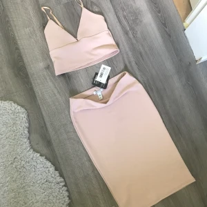  - Säljer ett helt nytt set från Nelly, prislapparna är kvar och överdelen är endast testad. Kjolen passar även en S/M, beror på hur man vill att den ska sitta.