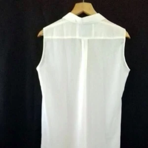  - En aldrig använd klänning utan armar med knäppning och som går till knäna framtill och ned till vaderna baktill. 