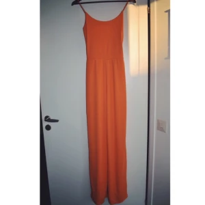  - En splitterny orange jumpsuit som kan användas till vardags och även på festliga tillfällen. 