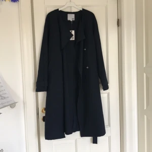  - Säljer en snygg marinblå kappa, perfekt som som sommarkappa! Ej använd pga inte min stil då jag fick den i present. 