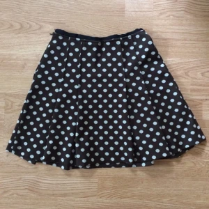  - 🍂Jättefin vintagekjol i mörkbrunt med gräddvita prickar. Passar sig året runt, gärna med en sliten retro tisha eller enfärgad topp. Okänt märke. Märkt 38, men passar 34-36. Materiallapp borta, gissar på viskos. Välanvänd & omtyckt, men gott beg.skick. Litet hål baktill. Frakt: +35kr.🍂