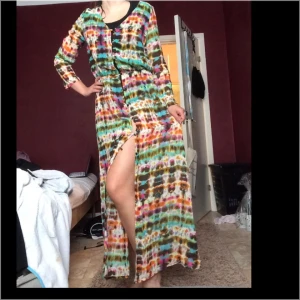  - Mönstrad långklänning/kofta (man kan ha den lite hur man vill) som går ner till fötterna i chiffongtyg (jag är 170 cm) knappar längst med framsidan som man kan välja att ha stängt eller öppna som man vill. Resår i midjan. Jättefin och aldrig använd! 