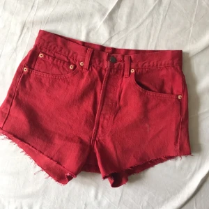  - Röda Levis-shorts som är avklippta.