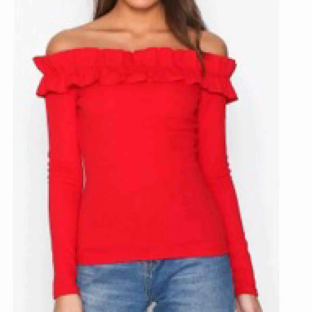 Röd figursydd of shoulder tröja med volanger uppe. Använd fåtal gånger. Köpt på Nelly, dåligt ljus på första bilden, andra bilden är hur färgen egentligen är. Toppar.