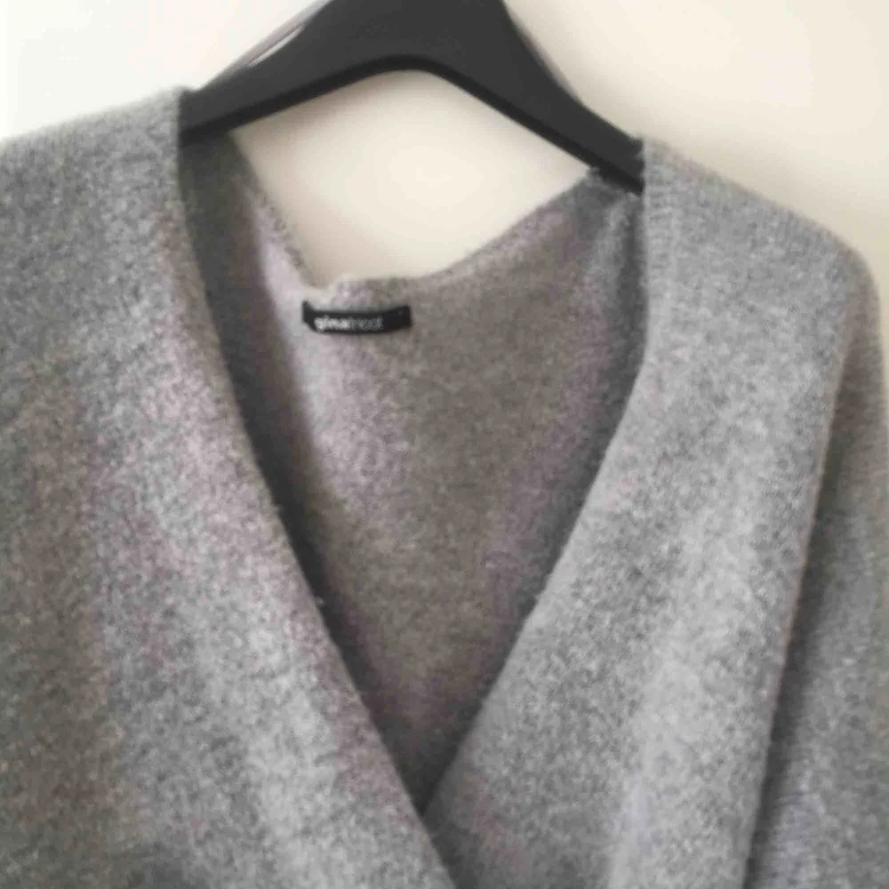 En grå stickad omlott tröja i st L. Nästan aldrig använd. Köparen betalar frakten. Stickat.