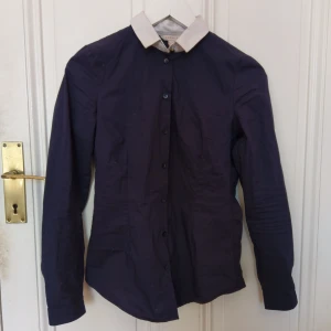  - Marinblå skjorta med vit krage från Esprit. Smickrande figursydd modell! Såg inte att det var sminkfläckar på kragen när jag fotade, jag tvättar den naturligtvis innan köp 🙈  72% bomull, 25% nylon, 3% elastan.