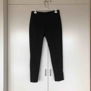  - Svart kostymbyxa i rak modell, uppvikbar nedtill. Köparen står för evt frakt. 