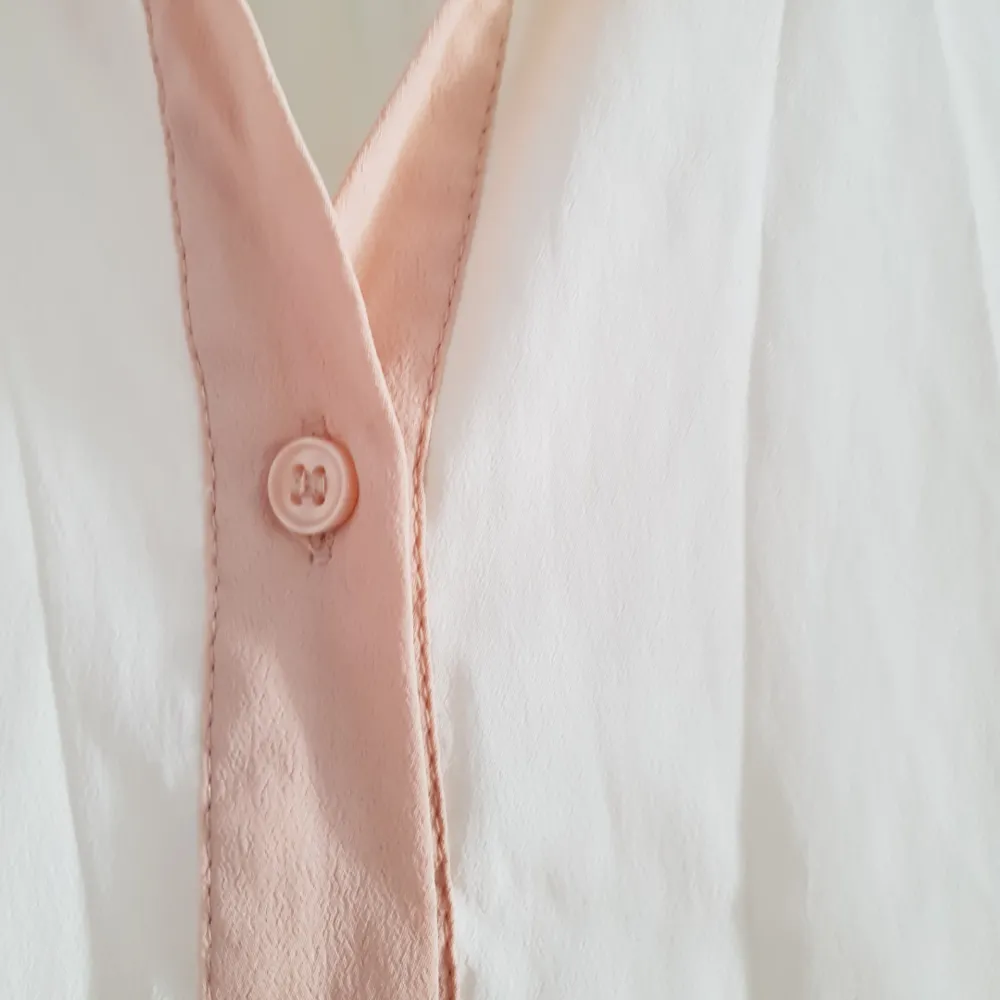Skjorta i fint material, vaniljvit med rosa detaljer! . Skjortor.