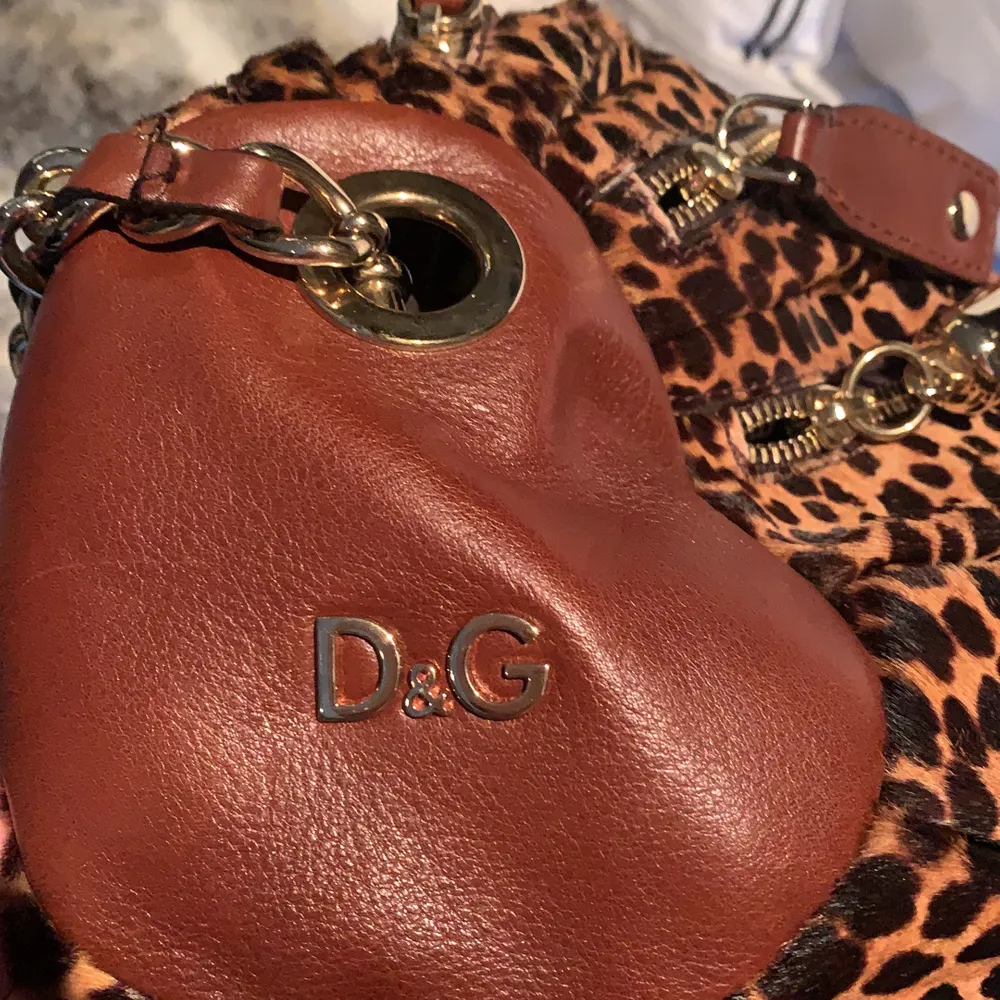 Min mammas gamla äkta Dolce & Gabbana väska! Leopard med bruna och guldiga detaljer. Cirka 10 år gammal. Rymlig med 7 st fack i olika storlekar. Justerbart axelband. Äkta skinn. Startpris på 450kr. Väskor.