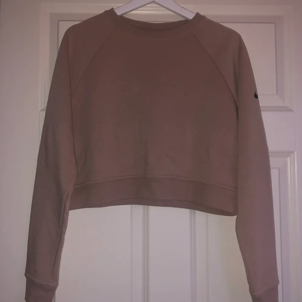 Säljer denna croppade sweatshirt från Nike. Den är beige i storlek S, Dri-fit. Frakt tillkommer. Hoodies.