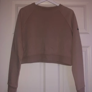 Croppad sweatshirt från Nike - Säljer denna croppade sweatshirt från Nike. Den är beige i storlek S, Dri-fit. Frakt tillkommer
